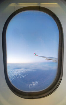 Airplane window view showing MEA aircraft wing with Lebanese cedar emblem above dense clouds during peaceful high-altitude flight with clear sky