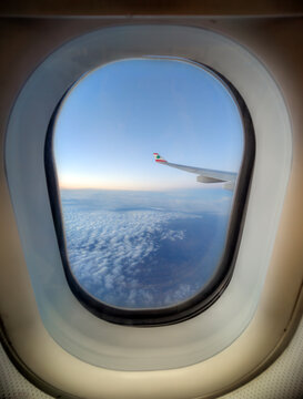 Airplane window view showing MEA aircraft wing with Lebanese cedar emblem above dense clouds during peaceful high-altitude flight with clear sky