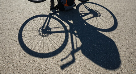 Shadow of a Bicycle on an Asphalt Surface During Daylight