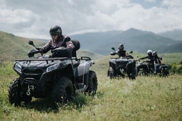 Adventure enthusiasts exploring the outdoors together on quad bikes amidst picturesque mountain settings.