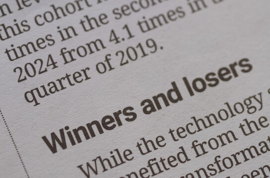 A financial report with the bold headline "Winners and losers" in sharp focus, symbolizing the constant competition and fluctuating outcomes in business and investment.