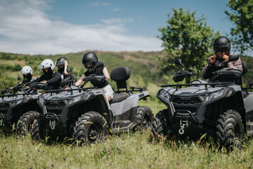 Friends prepares for an exciting off-road adventure on their quad bikes in a scenic natural...