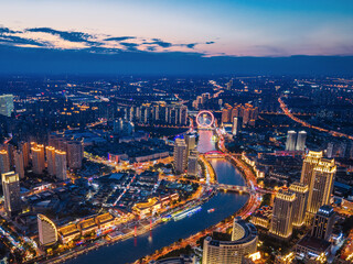Aerial night view of Tianjin Eye Ferris wheel and city skyline in Tianjin, China