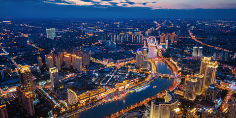 Aerial night view of Tianjin Eye Ferris wheel and city skyline in Tianjin, China