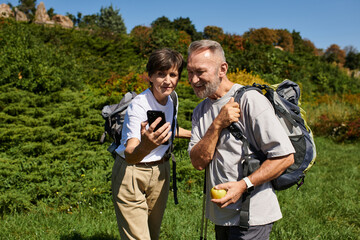 Senior couple enjoys their adventure while hiking in the mountains together