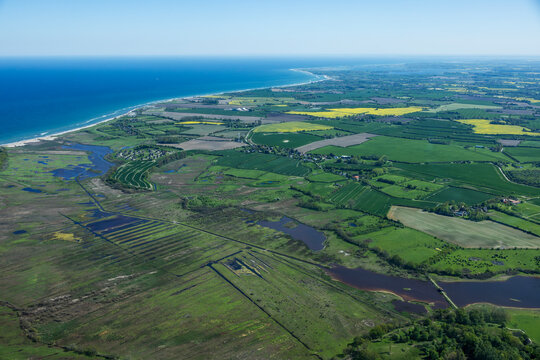 Aerial landscape of islands and coastal areas with colorful green fields and blue waters of the Baltic Sea in Denmark.