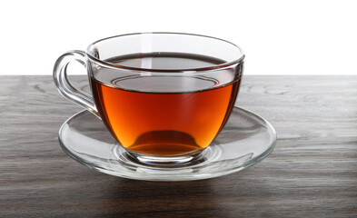 Cup of aromatic black tea on dark wooden table against white background