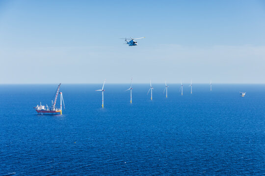 Helicoptor flying over a wind farm in the Baltic Sea returning from a crew change at an installation vessel..