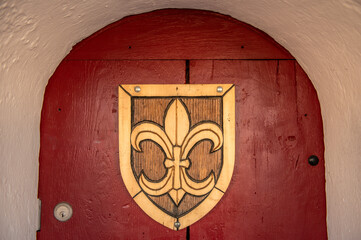 Historische Holztüre mit Wappen und Rundbogen am Reißturm in Nördlingen an umlaufender Stadtmauer mit überdachtem Wehrgang an der Reimlinger Mauer
