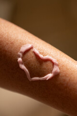 Fototapeta premium Woman's hand with cream. Heart. Cosmetology. 