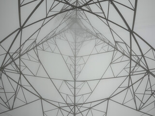 Obraz premium A power pole on a hill in foggy weather, photographed bottom up