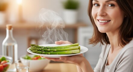 A radiant woman presents a steaming plate of freshly cooked green asparagus, showcasing a moment of healthy living and culinary delight. Her genuine smile conveys happiness and satisfaction, suggestin