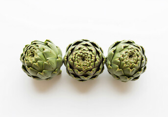 Obraz premium Three fresh artichokes isolated on a white background