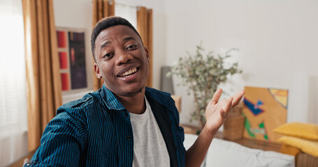 In a freshly bought house, a young man records a message for his loved ones. He looks into the camera, speaks with excitement, and points to boxes in the background.