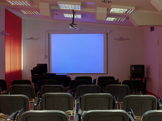 Empty conference room with blank projector screen