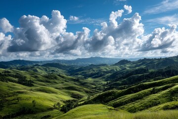 Obraz premium Rolling green hills under blue sky with fluffy clouds