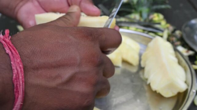 Pineapple or Ananas comosus chopping with knife. It is a&nbsp;tropical plant&nbsp;with an edible fruit. It is plant in the family&nbsp;Bromeliaceae. Fruits cutting. 
