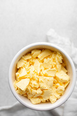 Overhead view of organic butter in a white plate with handle, natural yellow butter from grass fed cows