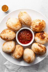 Overhead view of a plate of masa and pepper sauce, top view of food from northern nigeria masa waina rice cake and stew