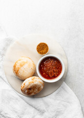 Overhead view of a plate of masa and pepper sauce, top view of food from northern nigeria masa waina rice cake and stew