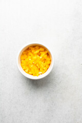 Overhead view of sliced yellow bell peppers on a marble countertop, top view of diced yellow bell peppers