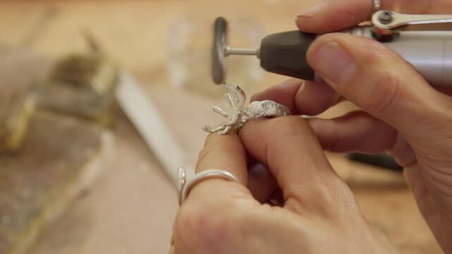 Jeweler polishing a ring with a tool