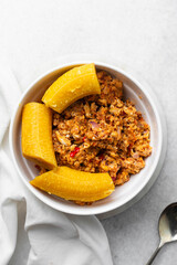 overhead view of Boiled ripe plantain with tomato scrambled eggs in a white bowl, top view of nigerian egg and plantain