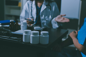 Female doctor holding a medicine bottle is checking the quality of medicine for any side effects the patient or not and recording patient information at the hospital. medical and health care concept