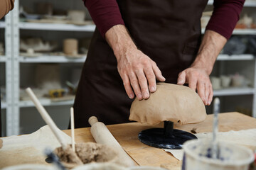 Young man engaged in pottery creation at a vibrant studio while exploring his artistic passion