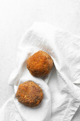 Overhead view of fried scotch eggs on white napkin