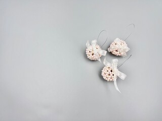 Christmas decorations balls made of large shiny beads with a lace bow in a Scandinavian minimalist style, top view on a light background