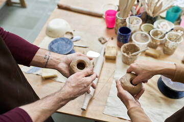 Joyful moments of a young couple creating pottery together in an artistic studio space
