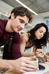 Creating art together in a pottery studio brings joyful moments to a young couples day