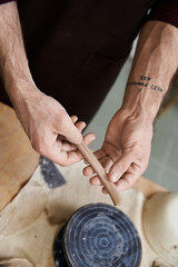 Handsome young man shaping clay in a pottery studio, exploring his creative hobby