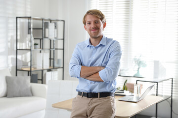 Fototapeta premium Portrait of young man near table indoors