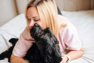 Tender moment of an owner and their dog hugging and caring for a pet in a comfortable home environment.