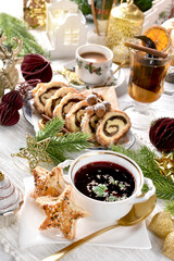 Christmas Eve table with traditional red borscht with star shaped puff pastry pies and cake