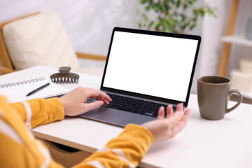 Fototapeta premium Woman working with laptop at white table indoors, closeup. Mockup for design