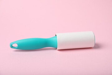 One sticky lint roller on pink background