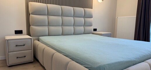 Stylish bedroom interior with comfortable large bed and nightstands