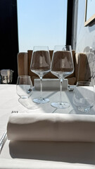 Sunlit wine glasses on crisp linens evoke serene tranquility, perfect for Midsummer Night fete or gastronomic escapade