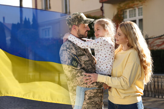 Happy military man and his family outdoors. Double exposure with flag of Ukraine