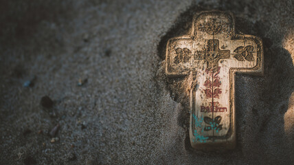 Wooden cross resting in sandy ground with floral designs representing faith and spirituality