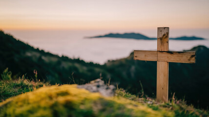 Cross on a hilltop overlooking a misty valley during sunset in a peaceful setting