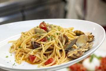 Close-up of delicious fish pasta cooked with fresh tomatoes and garlic sauce on a dish
