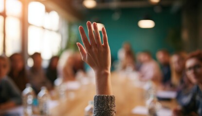 Person raising hand in a classroom or meeting room with attentive audience