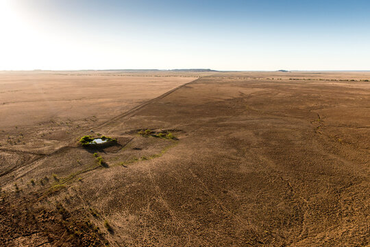 Small waterhole surrounded by arid plains near Middleton in the Queensland outback