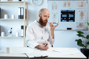 Doctor recording a voice message to his patient.
