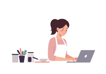 Woman in apron uses laptop beside jars and kitchen utensils