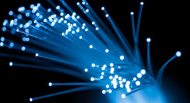 This abstract and futuristic image captures the essence of advanced technology with a vibrant display of glowing blue fibers against a deep, dark background. The intricate network of illuminated stran
